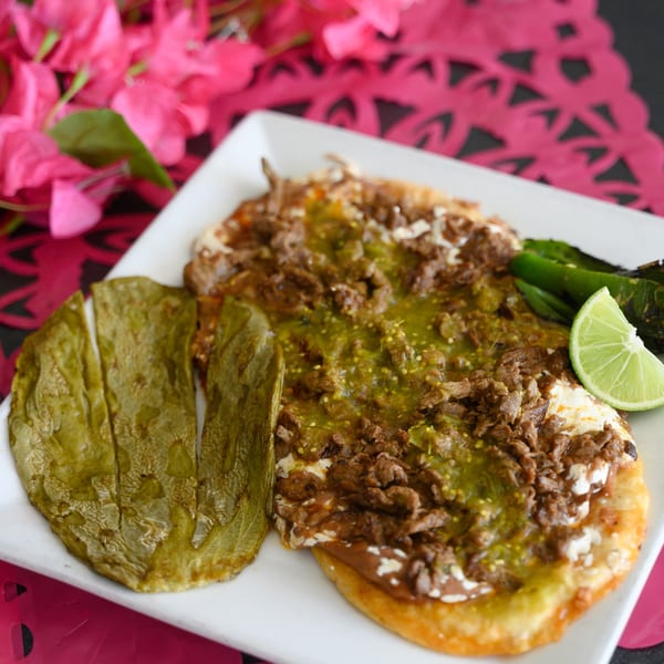 Papa Joe's Mexican Restaurant's sopes with green salsa, meat, cheese, nopales, and lime.
